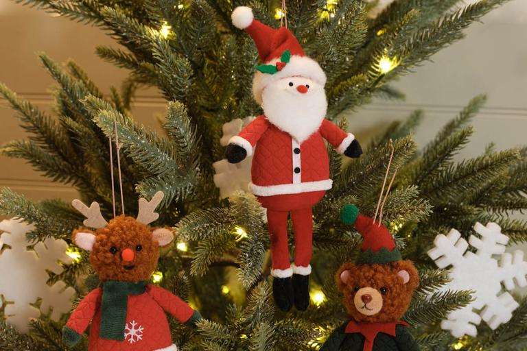A close-up shot of soft tree ornaments of Santa, a reindeer and a bear.