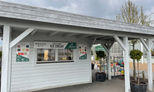 Image shows The Potting Shed cafe, a sheltered wooden kiosk